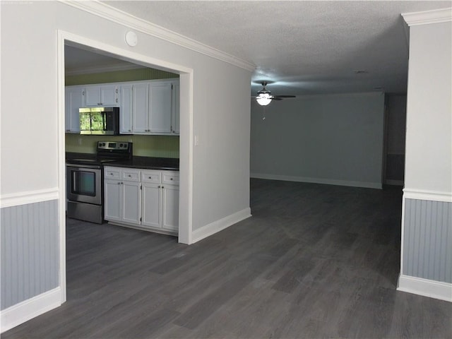 kitchen featuring appliances with stainless steel finishes, white cabinetry, a textured ceiling, and dark hardwood / wood-style flooring