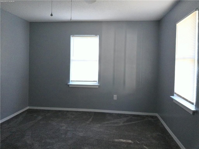 carpeted empty room with a textured ceiling