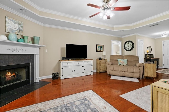 7115 Haleys Way, Theodore, AL 36582 - living area with dark wood finished floors, ceiling fan, a tile fireplace, crown molding, and baseboards