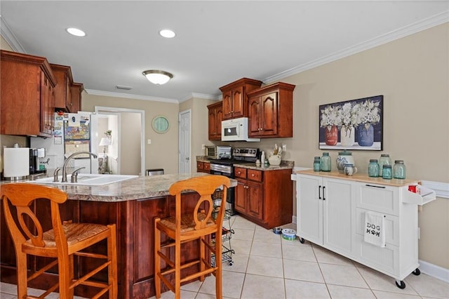 7115 Haleys Way, Theodore, AL 36582 - kitchen featuring white microwave, a sink, stainless steel electric stove, a breakfast bar area, and light tile patterned floors