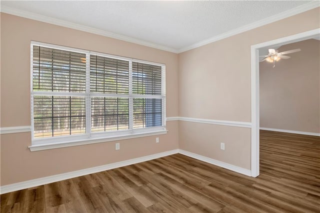 unfurnished room featuring crown molding, ceiling fan, baseboards, and wood finished floors