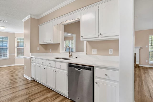 kitchen featuring light wood-style flooring, a sink, white cabinetry, stainless steel dishwasher, and crown molding