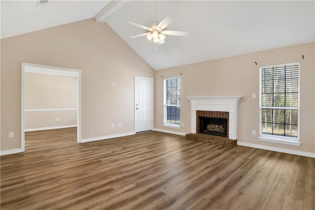 unfurnished living room with beamed ceiling, a fireplace, wood finished floors, and a ceiling fan