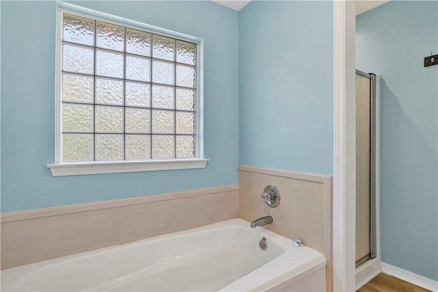 bathroom with a garden tub and a shower stall