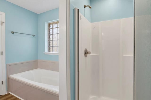 full bathroom featuring a shower stall and a bath