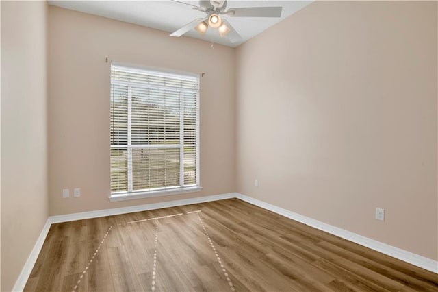 unfurnished room featuring ceiling fan, baseboards, and wood finished floors