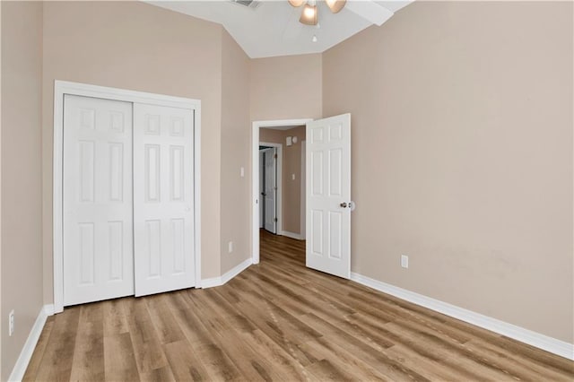 unfurnished bedroom featuring light wood-type flooring, a closet, and baseboards