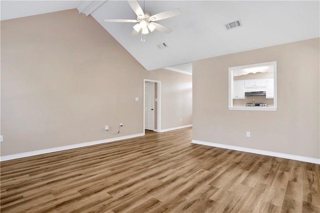 unfurnished living room featuring baseboards, visible vents, wood finished floors, and beamed ceiling