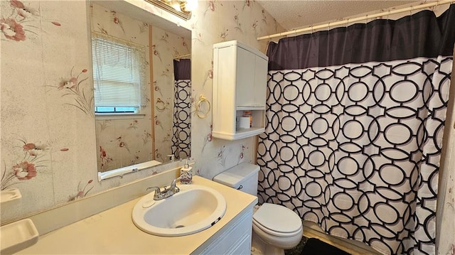 bathroom featuring toilet, a textured ceiling, and vanity with extensive cabinet space