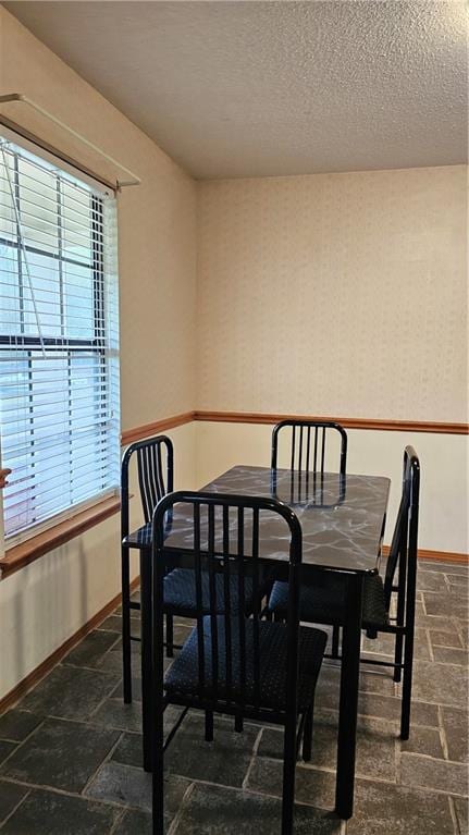 dining area with dark tile flooring and a textured ceiling