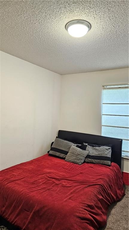 bedroom featuring a textured ceiling and carpet floors