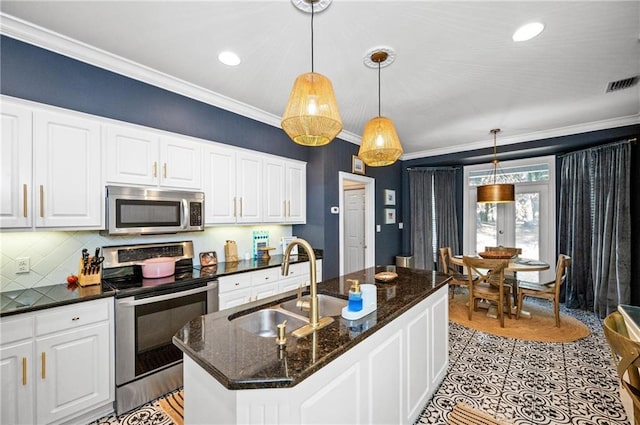 kitchen with white cabinetry, stainless steel appliances, sink, hanging light fixtures, and a center island with sink