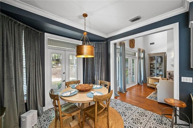 dining area featuring french doors, ornamental molding, and hardwood / wood-style flooring