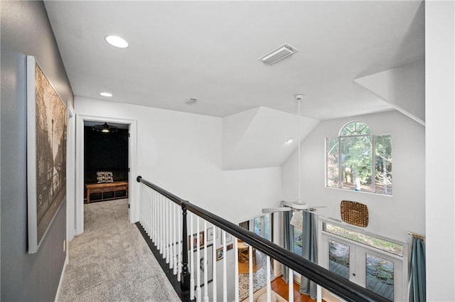 corridor with light carpet, lofted ceiling, and french doors