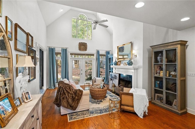 living area featuring a high end fireplace, dark hardwood / wood-style flooring, french doors, high vaulted ceiling, and ceiling fan