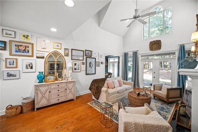 living area featuring high vaulted ceiling, ceiling fan, hardwood / wood-style flooring, and french doors