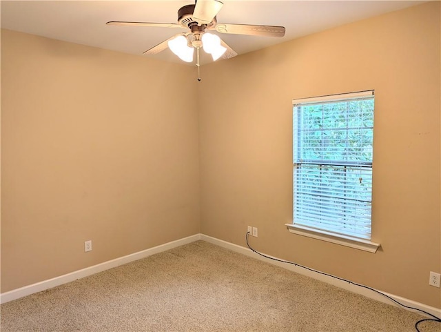 carpeted empty room with ceiling fan and baseboards