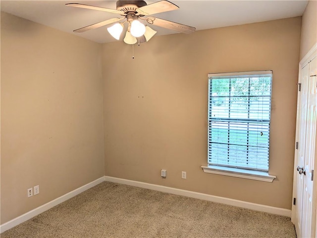 spare room featuring ceiling fan, baseboards, and light colored carpet