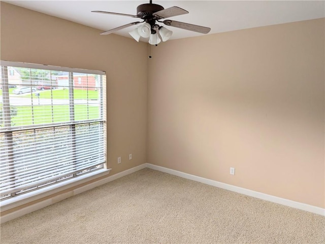 spare room featuring a ceiling fan, baseboards, and carpet flooring