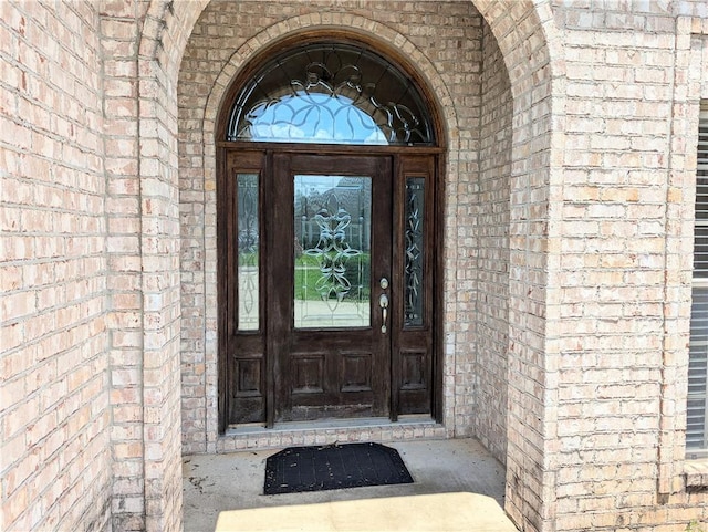 doorway to property featuring brick siding