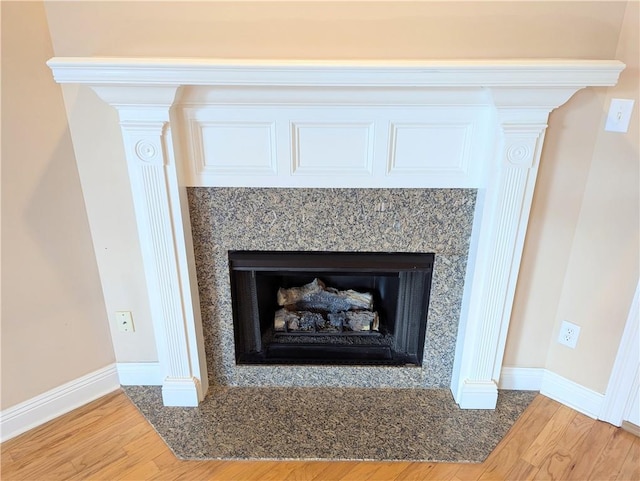 room details with a fireplace, baseboards, and wood finished floors