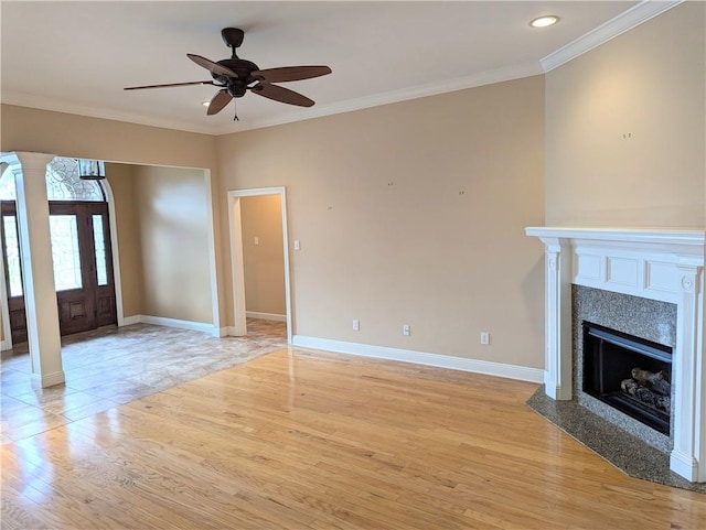 unfurnished living room featuring ornamental molding, decorative columns, light wood-style flooring, and baseboards