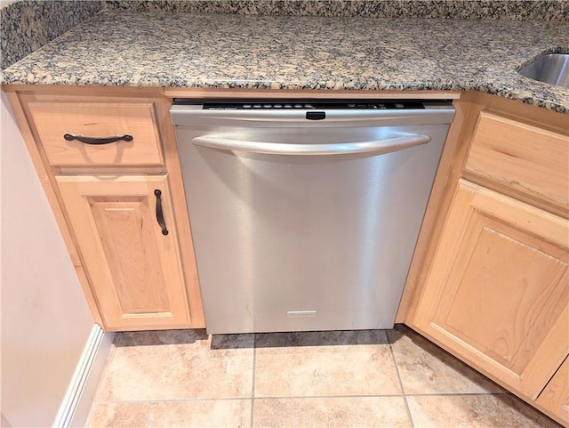 details with dark stone counters, stainless steel dishwasher, and light brown cabinets