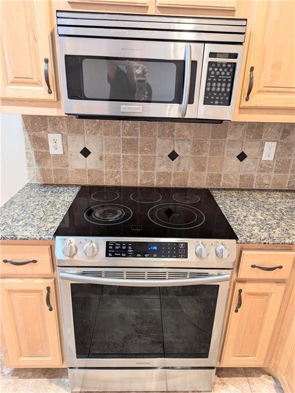 kitchen featuring light stone countertops, appliances with stainless steel finishes, and light brown cabinetry