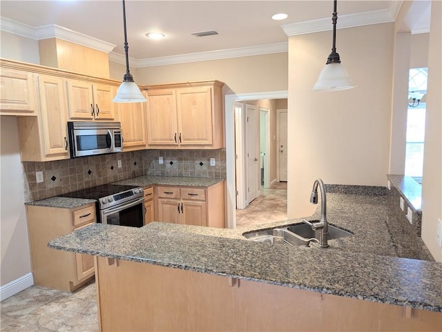 kitchen with a peninsula, appliances with stainless steel finishes, pendant lighting, and a sink