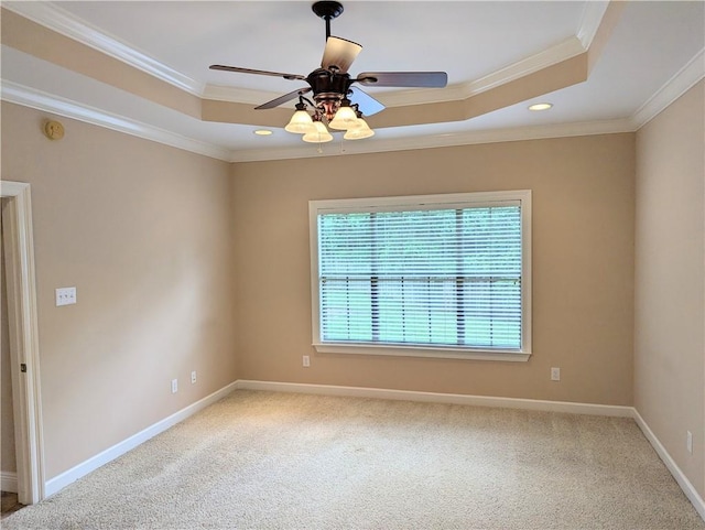 unfurnished room with a tray ceiling, ornamental molding, a ceiling fan, carpet flooring, and baseboards