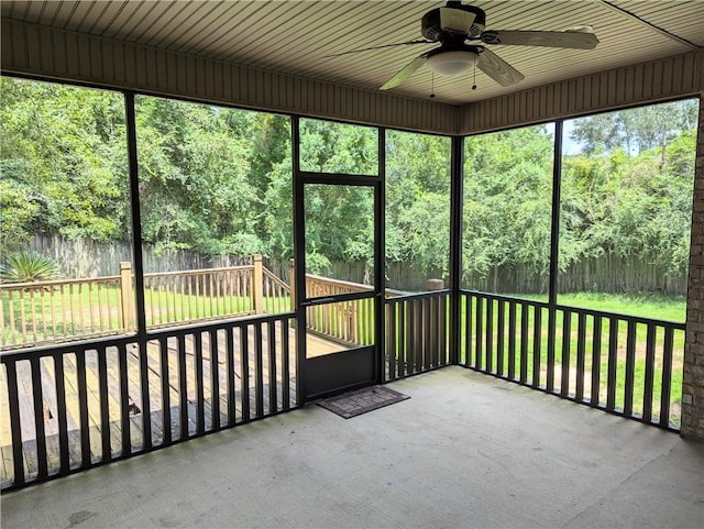 unfurnished sunroom with a ceiling fan