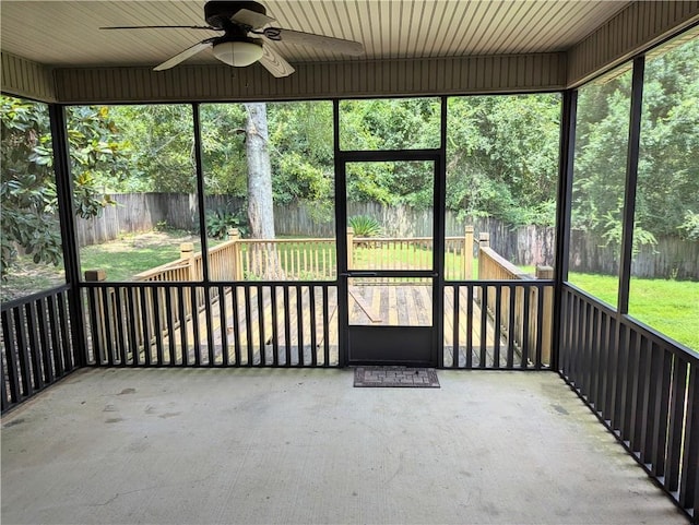 unfurnished sunroom with a ceiling fan and a wealth of natural light