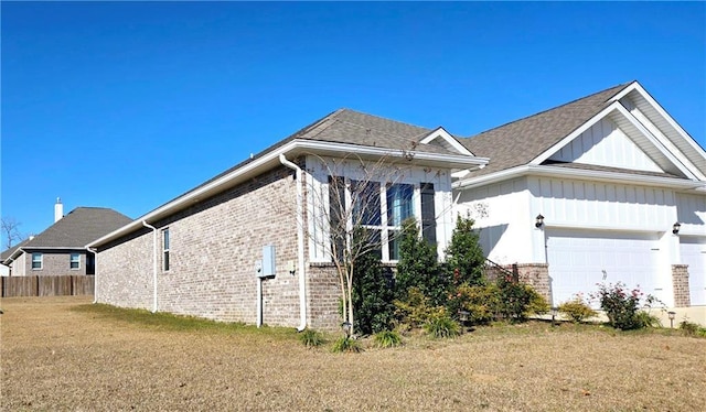 view of side of property with a yard and a garage