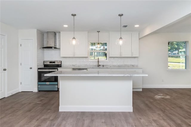 kitchen featuring white cabinetry, stainless steel electric range, a center island, and wall chimney exhaust hood