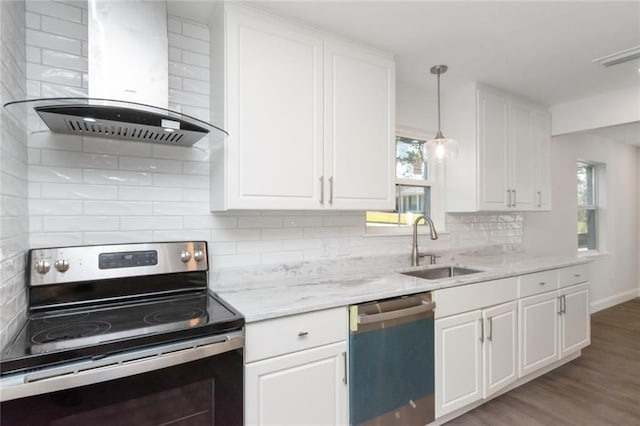 kitchen with wall chimney range hood, sink, white cabinets, and appliances with stainless steel finishes