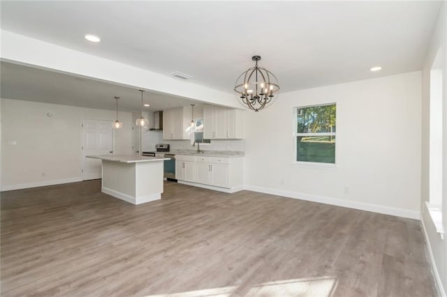 unfurnished living room with a notable chandelier, sink, and light wood-type flooring