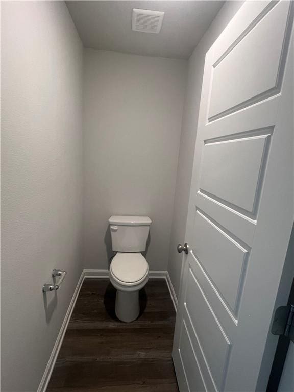 bathroom with toilet and wood-type flooring