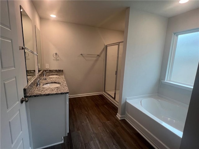 bathroom featuring plus walk in shower, vanity, and hardwood / wood-style flooring