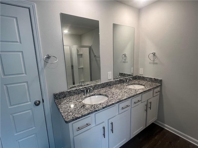 bathroom featuring a shower with shower door, wood-type flooring, and vanity