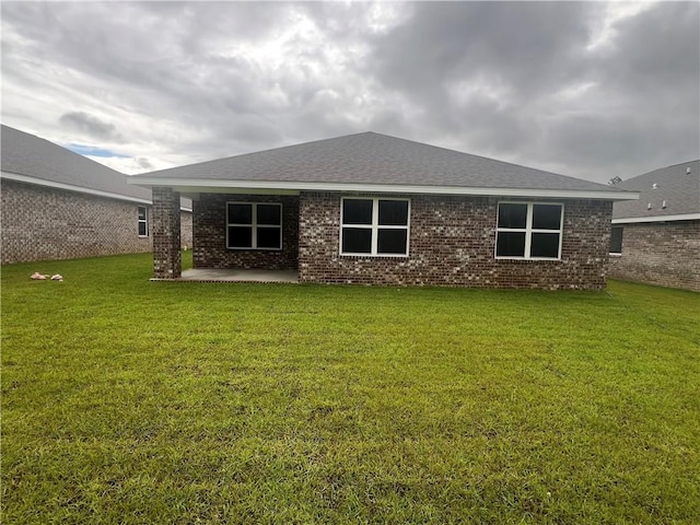 rear view of property featuring a patio and a lawn