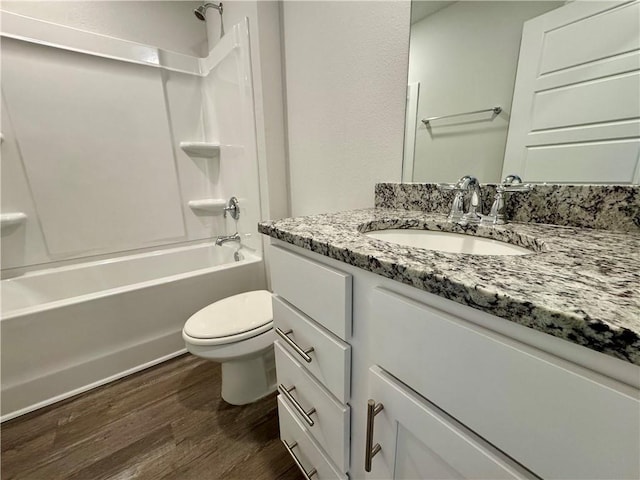 full bathroom featuring toilet, wood-type flooring, vanity, and washtub / shower combination