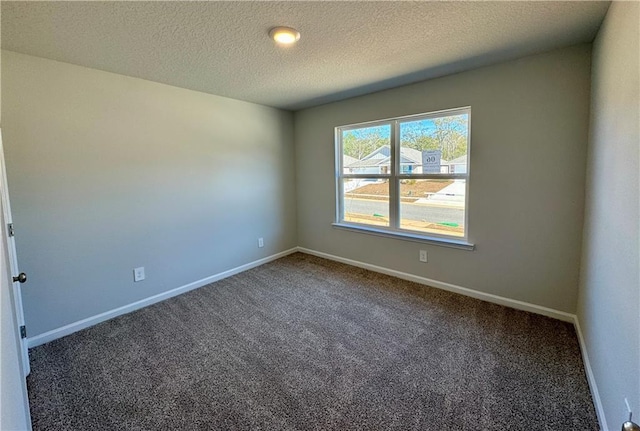 carpeted empty room featuring a textured ceiling