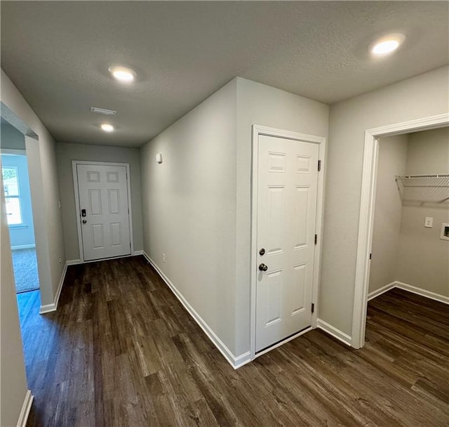 hallway with dark hardwood / wood-style flooring and a textured ceiling