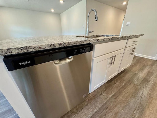 kitchen with dark wood-type flooring, dishwasher, a kitchen island with sink, white cabinets, and sink