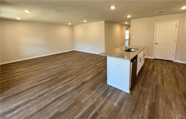 kitchen featuring sink, dark hardwood / wood-style flooring, an island with sink, and white cabinets