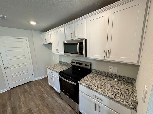 kitchen with white cabinets, stainless steel appliances, and light stone countertops