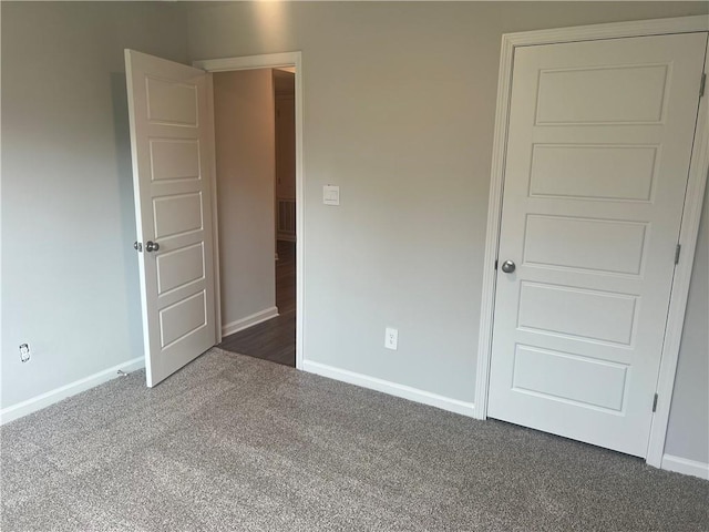 unfurnished bedroom featuring dark colored carpet