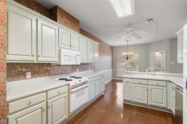 kitchen with sink, white appliances, white cabinetry, dark hardwood / wood-style floors, and decorative light fixtures