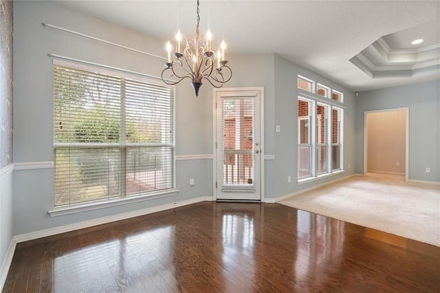 interior space featuring an inviting chandelier, a tray ceiling, plenty of natural light, and dark hardwood / wood-style floors