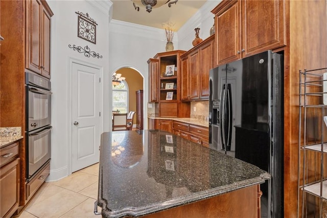 kitchen featuring arched walkways, light tile patterned flooring, black appliances, open shelves, and ornamental molding
